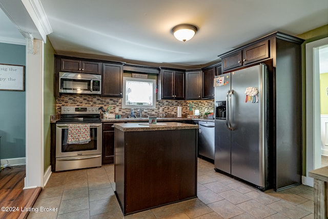 kitchen featuring ornamental molding, tasteful backsplash, a kitchen island, dark brown cabinets, and stainless steel appliances