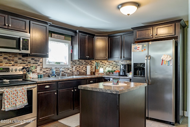 kitchen featuring a kitchen island, stainless steel appliances, tasteful backsplash, light tile patterned flooring, and dark brown cabinets