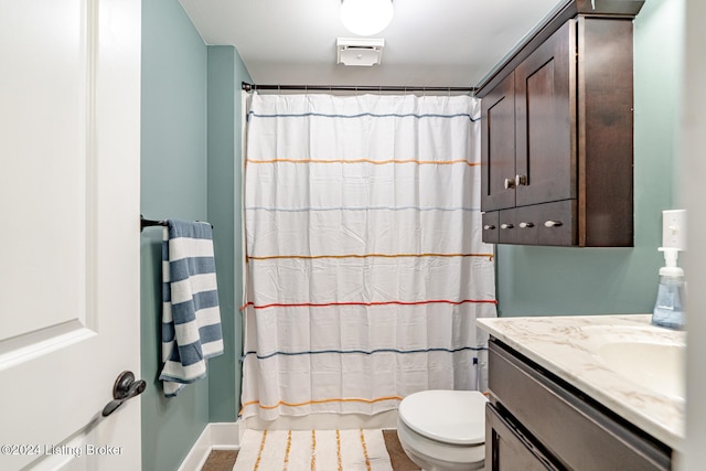 bathroom featuring walk in shower, vanity, and toilet