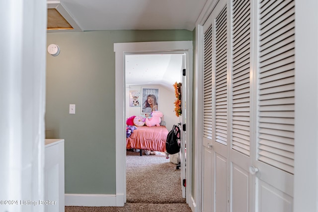 hallway with lofted ceiling and carpet