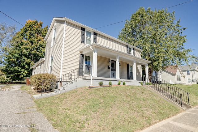 view of front of home with a front yard and covered porch