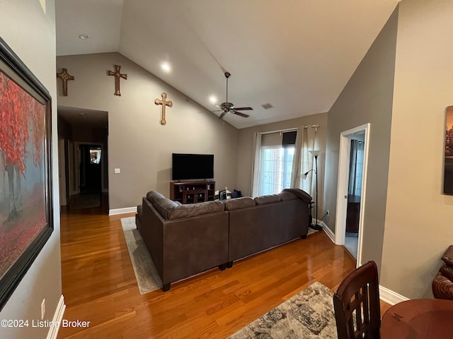 living room featuring light hardwood / wood-style floors, vaulted ceiling, and ceiling fan