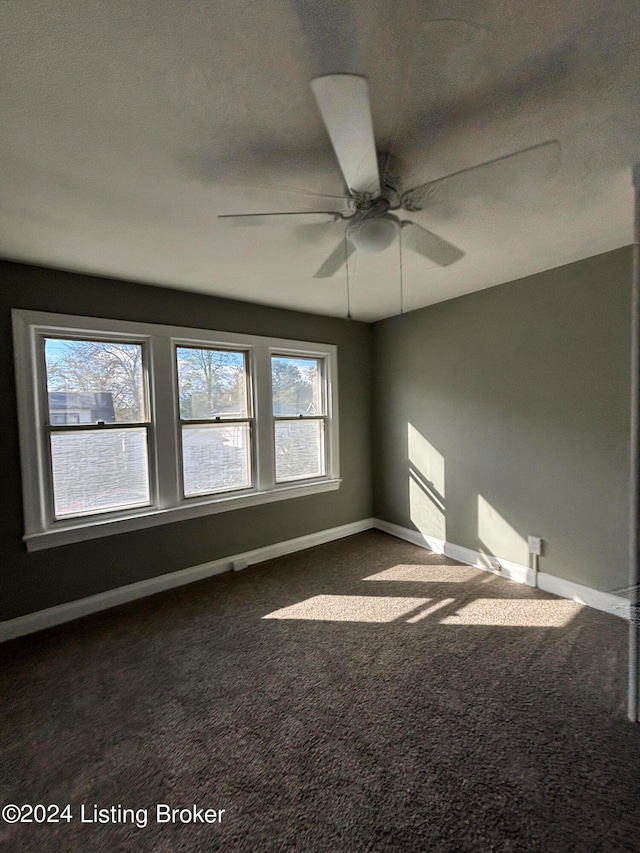 carpeted empty room featuring ceiling fan and a textured ceiling