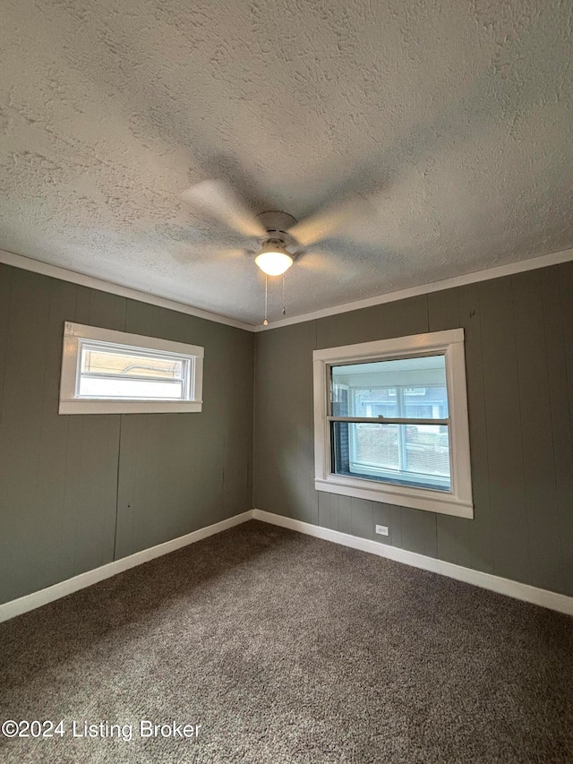 carpeted spare room featuring crown molding, a textured ceiling, and ceiling fan