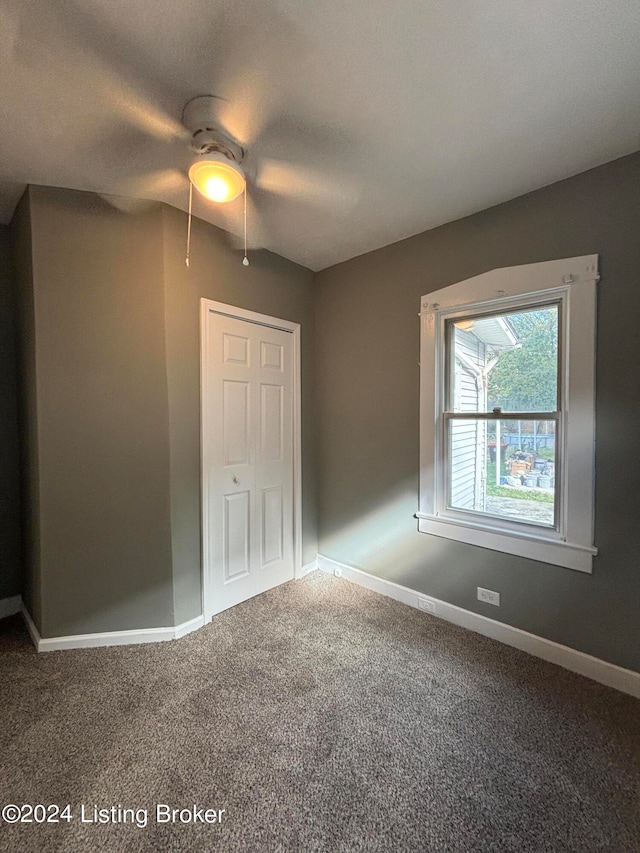 unfurnished bedroom with a closet, carpet flooring, and ceiling fan