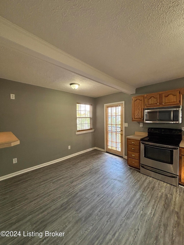 kitchen featuring a textured ceiling, appliances with stainless steel finishes, beam ceiling, and dark hardwood / wood-style flooring