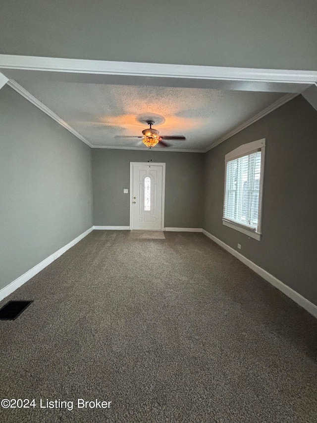 foyer entrance featuring ornamental molding, carpet flooring, a textured ceiling, and ceiling fan