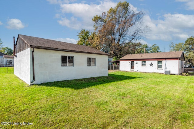 back of property featuring cooling unit and a lawn