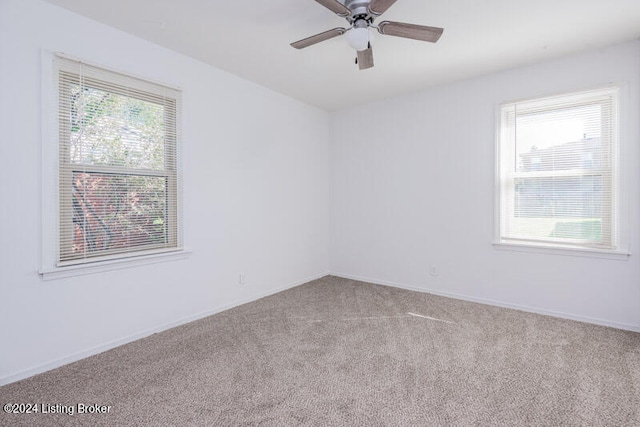 carpeted spare room featuring ceiling fan