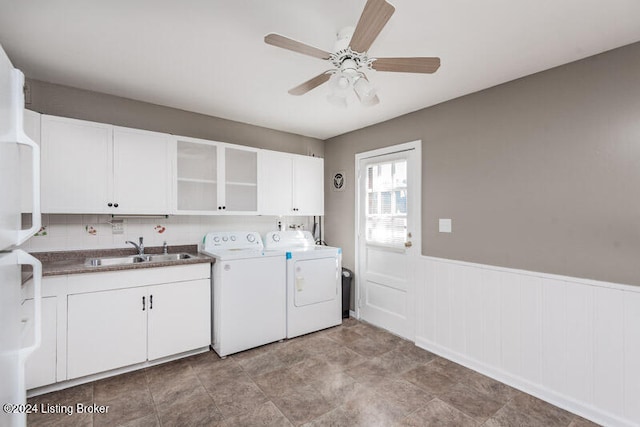 washroom featuring ceiling fan, cabinets, sink, and washing machine and clothes dryer