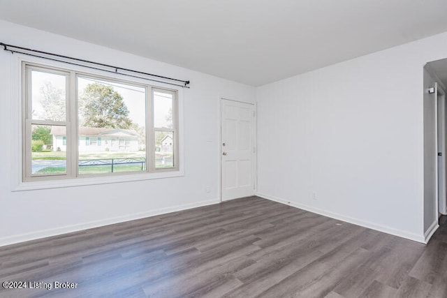 unfurnished room with dark hardwood / wood-style flooring