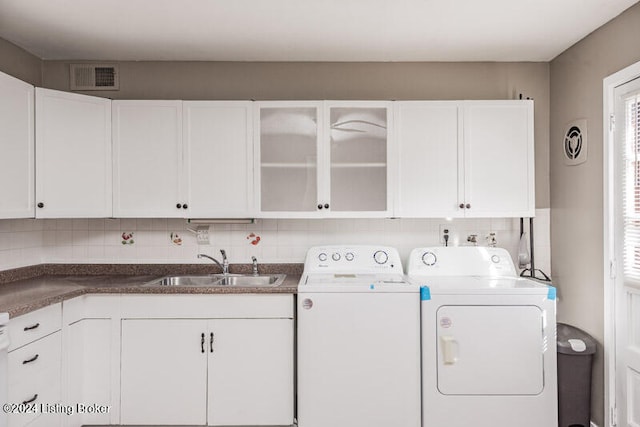 washroom featuring washer and dryer, cabinets, and sink