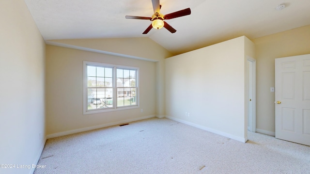 spare room featuring lofted ceiling, ceiling fan, and light colored carpet