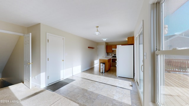 kitchen featuring stainless steel range with electric stovetop, white fridge, and a breakfast bar