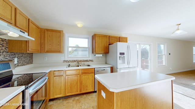 kitchen featuring appliances with stainless steel finishes, sink, decorative backsplash, and a center island