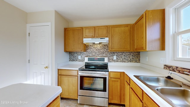 kitchen with backsplash, stainless steel range, and sink