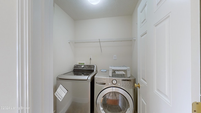 laundry room with washing machine and dryer and a textured ceiling