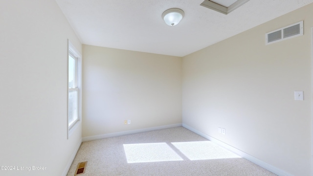 unfurnished room featuring light carpet