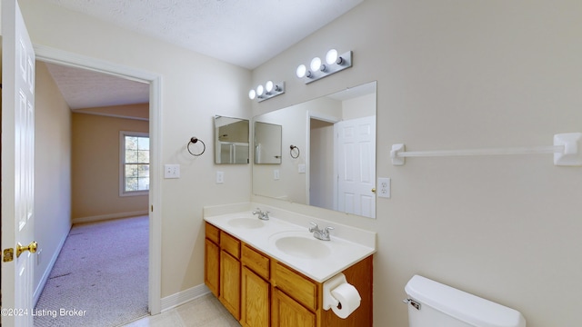 bathroom with vanity, toilet, and a textured ceiling