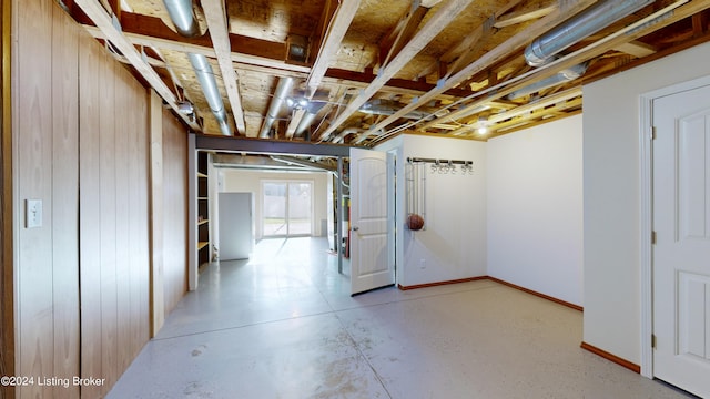 basement featuring wooden walls