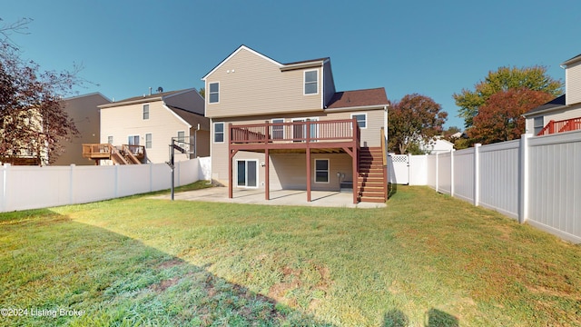 rear view of property featuring a patio area, a lawn, and a deck