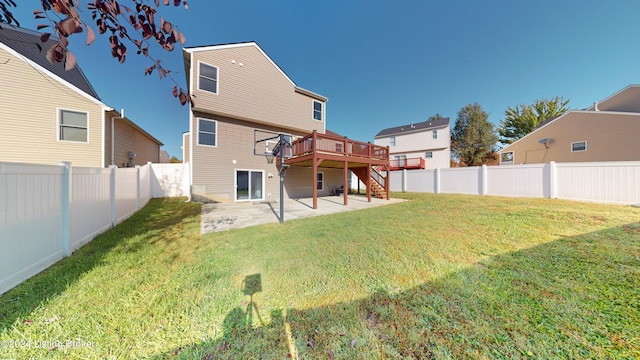 back of property with a yard, a deck, and a patio