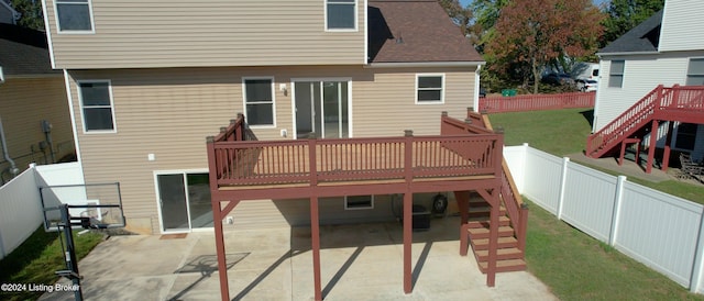 back of house featuring a wooden deck, a yard, and a patio