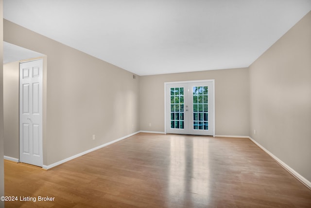 unfurnished room featuring french doors and light hardwood / wood-style flooring