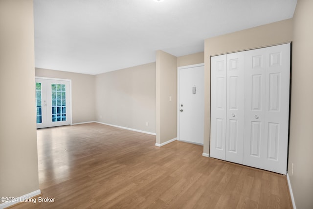 interior space with a closet, light hardwood / wood-style floors, and french doors