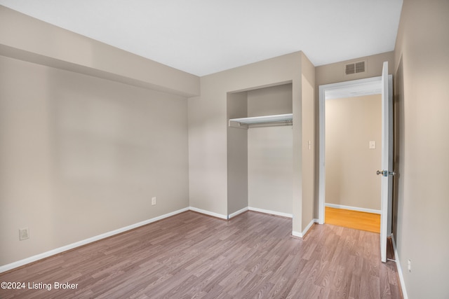 unfurnished bedroom with a closet and light wood-type flooring