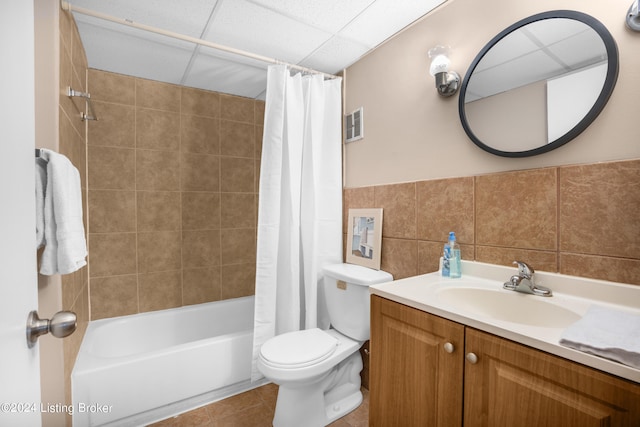 full bathroom featuring vanity, shower / bathtub combination with curtain, tile patterned floors, tile walls, and toilet