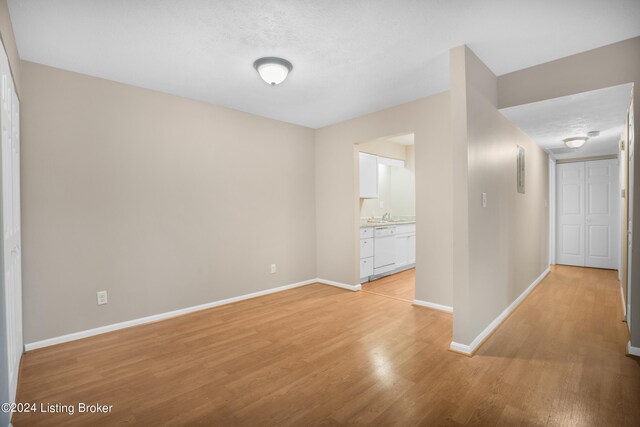 empty room featuring light wood-type flooring and a textured ceiling