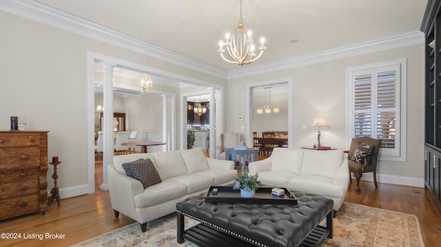 living room featuring wood-type flooring, crown molding, and a notable chandelier