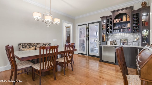 dining space featuring an inviting chandelier, crown molding, and light hardwood / wood-style floors