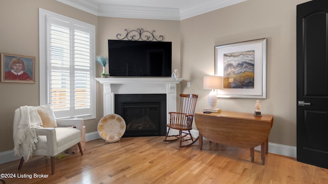 living area featuring light wood-type flooring, crown molding, and plenty of natural light