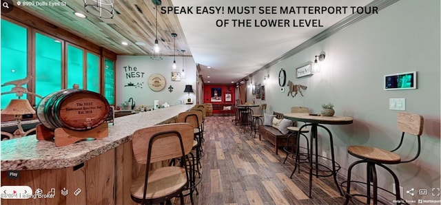 bar featuring ornamental molding, decorative light fixtures, and dark wood-type flooring