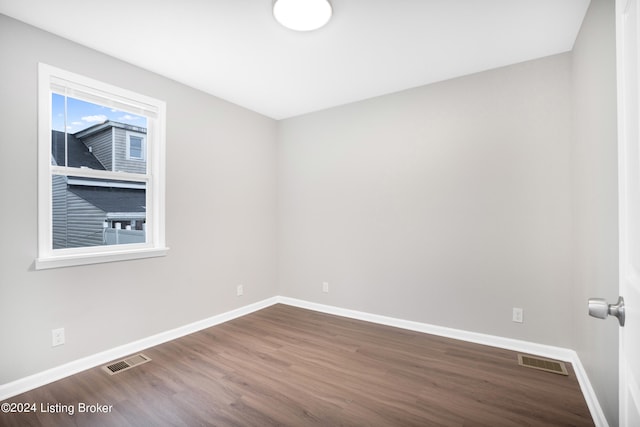 unfurnished room with dark wood-type flooring