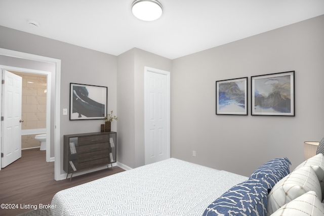 bedroom with connected bathroom and dark wood-type flooring