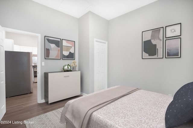 bedroom featuring dark hardwood / wood-style floors and stainless steel fridge