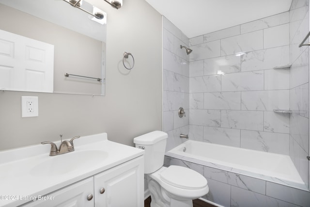 full bathroom featuring vanity, tiled shower / bath combo, and toilet