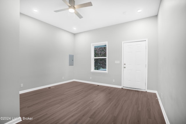 spare room with dark wood-type flooring, ceiling fan, and electric panel