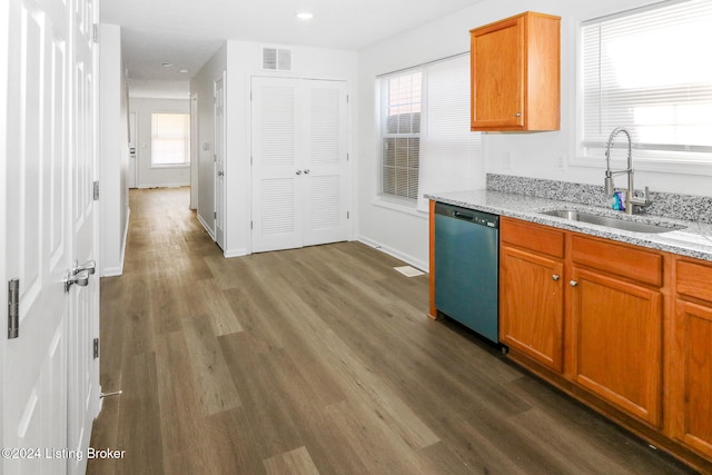 kitchen with light stone countertops, stainless steel dishwasher, a healthy amount of sunlight, dark wood-type flooring, and sink