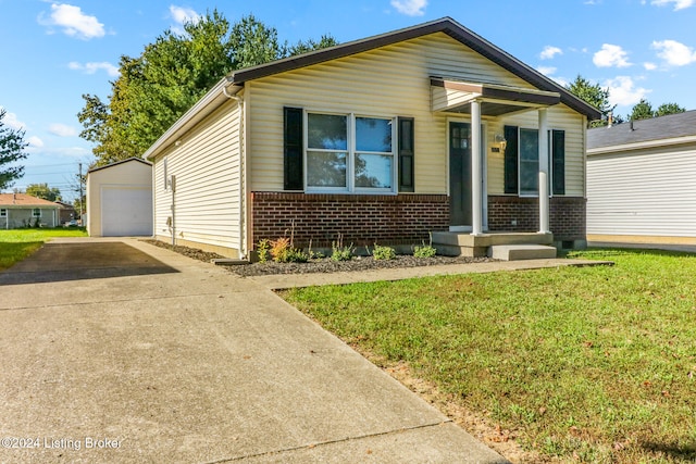 bungalow with an outbuilding, a garage, and a front lawn