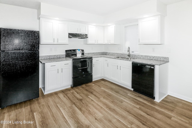 kitchen featuring white cabinetry, sink, black appliances, light hardwood / wood-style floors, and light stone counters