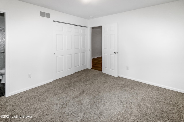 unfurnished bedroom featuring carpet flooring, connected bathroom, and a closet