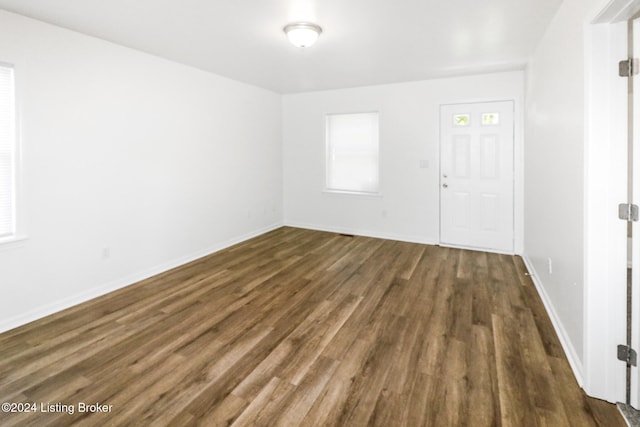 unfurnished room with dark wood-type flooring