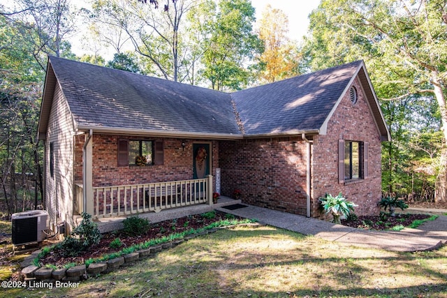 view of front of house with central AC unit, a front lawn, and covered porch