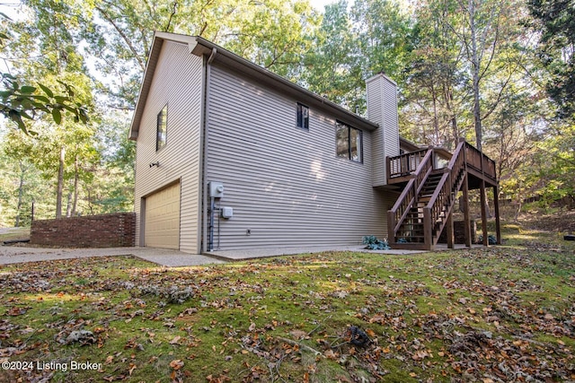 view of side of property with a garage and a wooden deck