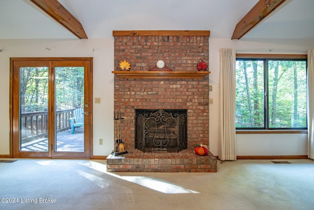 unfurnished living room featuring a brick fireplace, beamed ceiling, and carpet