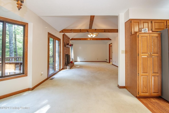 unfurnished living room with light carpet, a brick fireplace, ceiling fan, and lofted ceiling with beams